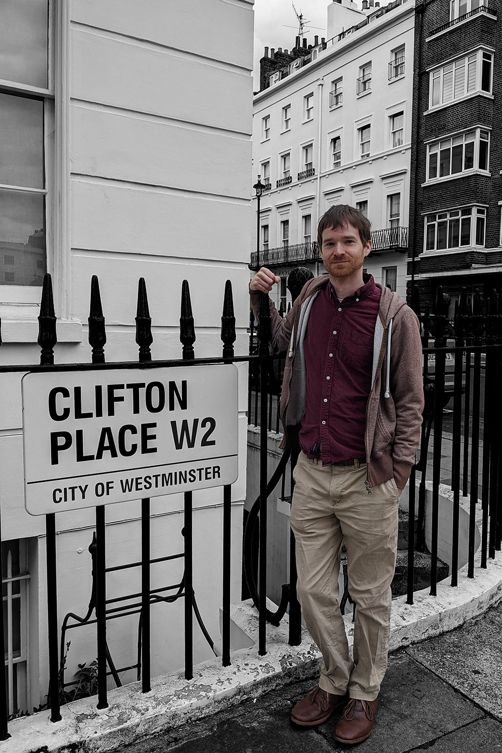 A man standing next to a sign that says Clifton Place