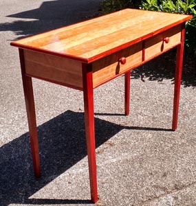 A simple writing desk with two drawers in the sun