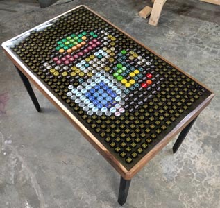 A table with embedded bottle caps that create a picture of Link from the Zelda video game series